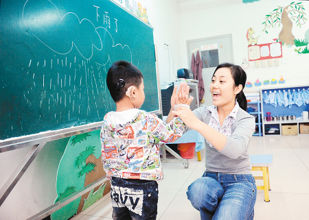 王老师经常用拍手来鼓励聋哑孩子. 记者 张宇明 摄