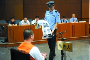 北京市一中院,被告人李磊受审时,法警为其出示证据.(资料图)