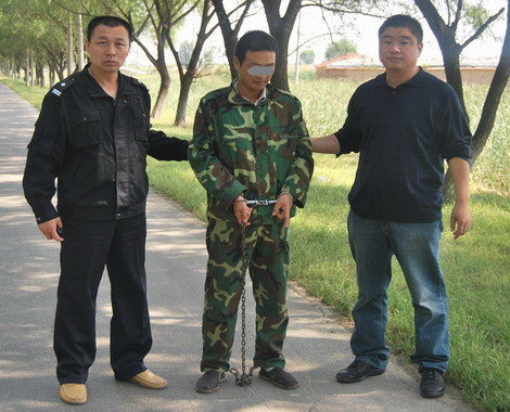 办案民警押解嫌疑人指认现场