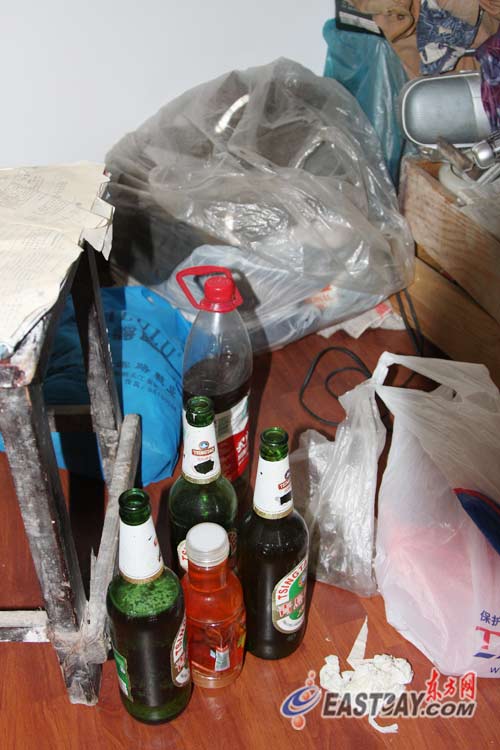 图片说明:陈某的桌子上还堆放着啤酒瓶,烟盒和饼干