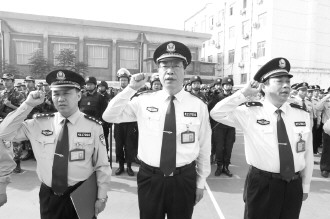 河南省第二监狱监狱长郭永禄(中)带领全体监狱警察职工庄严宣誓.