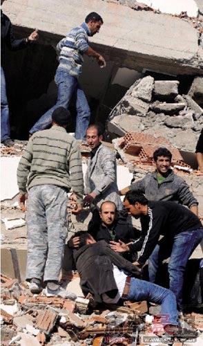 10月23日，土耳其东部凡省，一名地震伤者倒在建筑物废墟上。图/新华社