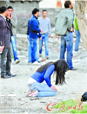 一名妇女在震后废墟中跪地痛哭.