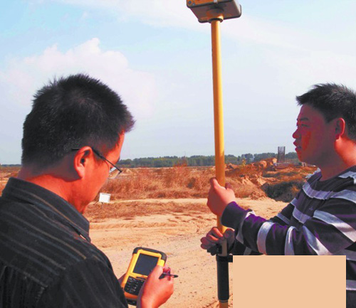 青岛工程人员正在用卫星定位仪器进行测量.