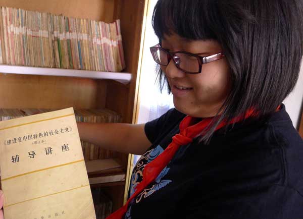 8月28日，在平涼市靈台縣上良鄉舊集小學原有的圖書室裏，小西向記者展示書櫃裏的陳年書籍。   王怡波攝