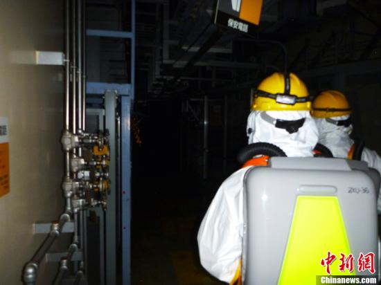 资料图：这张由日本东京电力公司在5月19日提供的照片显示，东电工作人员在18日进入福岛第一核电站2号机组核反应堆建筑内进行调查。
