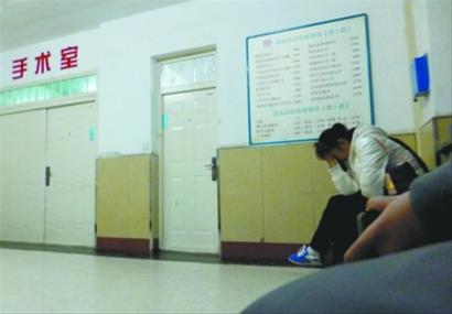 他的哥哥和姐姐赶到医院,在手术室外默默祈祷. 记者 王迪 摄