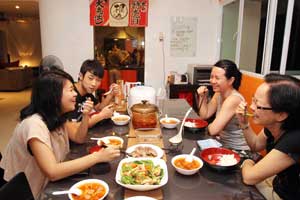 从事外国学生寄宿服务兼监护人的周毓慧（右二），与来自马国的理工学院生陈丽萦（左起）及来自广州的寄宿生刘宇童在家中享用晚餐。
