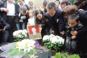 5日,在烈士牛作涛的骨灰安葬仪式上,英雄5岁的女儿和妻子(左二)
