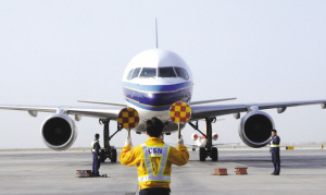在国际机场,地勤工作人员在引导飞机.