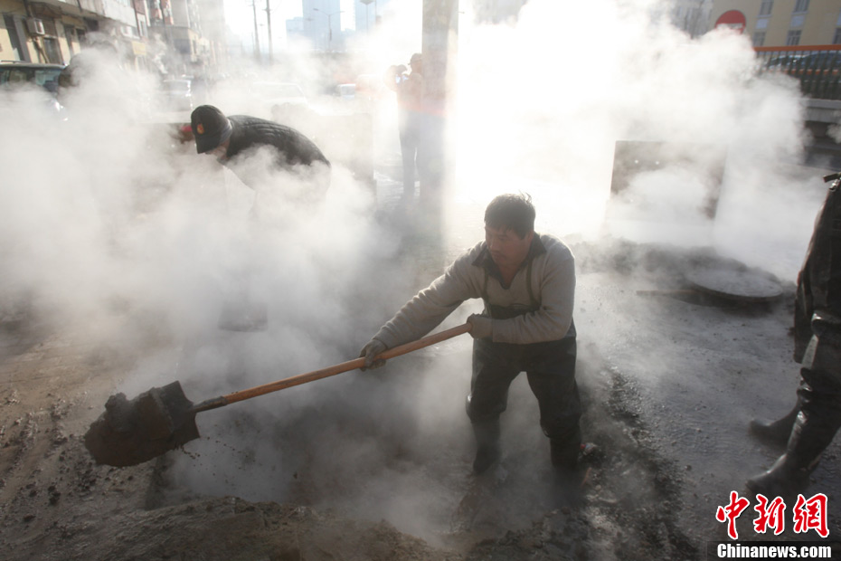 11月24日，哈尔滨市南岗区复华四道街上，一处供暖管线发生爆裂，事故现场烟雾弥漫，周围数百户居民供热受影响。目前该市工人正在进行抢修。中新社发 靖阳 摄 CNSPHOTO