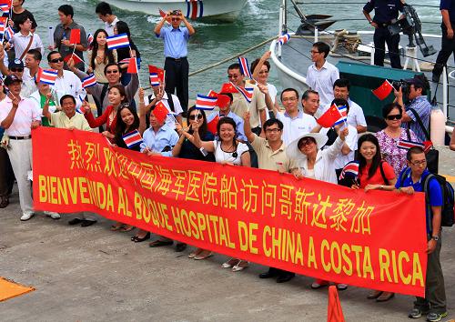 华人华侨在码头上拉起横幅欢迎"和平方舟"号医院船来访