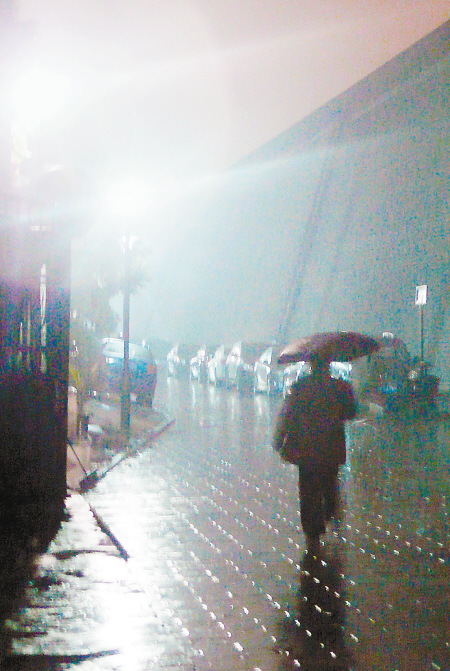 昨天傍晚,冬雨降落古城,晚归的人在雨中前行. 记者 尚洪涛 摄