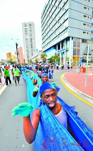 27日，南非一些舞者排成“蓝线”行走于德班沿海道路。