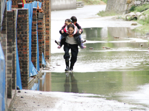 这条路因为下雨积了水,我本想拍车子开过的照片,结果看到这一幕,爸爸