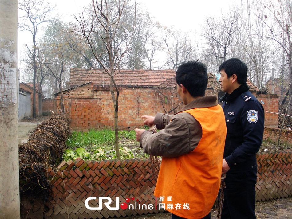 2011年12月06日,河南省周口市,项城警方押解嫌疑人到案发现场指认.