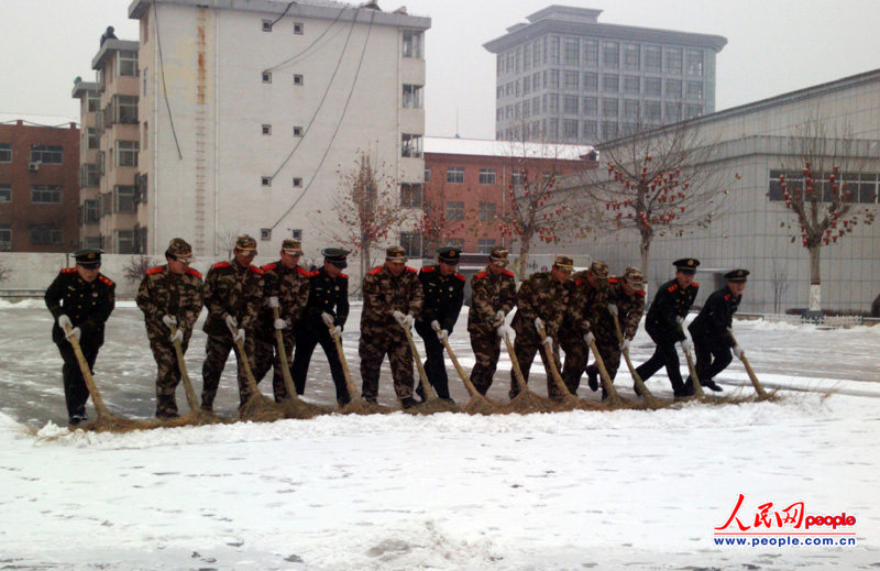 武警交通七支队三中队为市民清扫今冬第一场大雪(图)