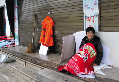 来自城西新区排塘村的卖菜老人梅阿公穿着雨衣,骑着三