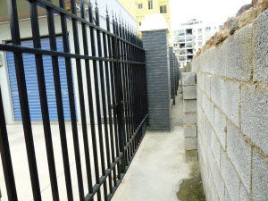 廉租房小区大门外就是东风木器厂建的一堵围墙。 本报记者 邓振福摄