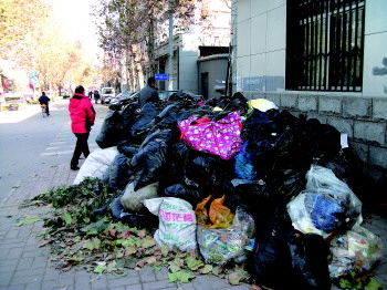 几十袋垃圾堆在路口 人行道成了垃圾中转站(图)