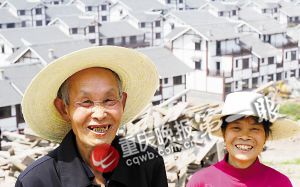 看着即将入住的新农房,江津区龙华镇燕坝村村民胡华满(左)笑得合不拢