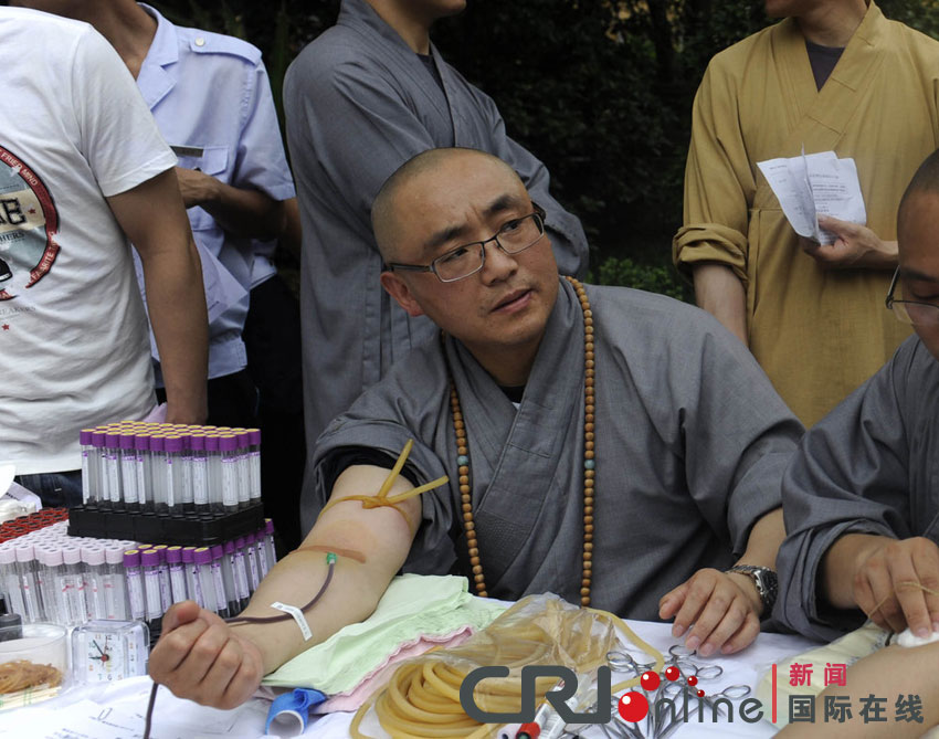 2011年7月1日，杭州，徐心联在寺庙以惟迪法师的名义献血。资料图国际在线发