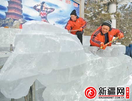 12月27日,在红山公园,冰雕师傅丁保军(右一)正在制作冰雕作品《达坂城