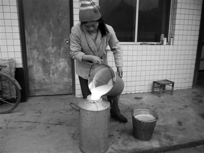12月28日，四川洪雅县阳坪村，一名奶农将攒了两天的奶倒入奶瓶准备出售。