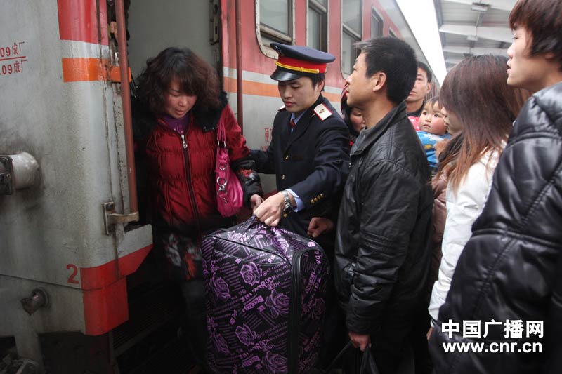 1月8日,春运第一天,湖南省娄底市火车站客运职工帮助旅客提行李下车.