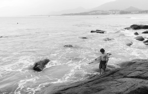 1月11日，比赛结束后。一位外国运动员拿着冲浪板再次下水继续享受在海南冲浪的乐趣。