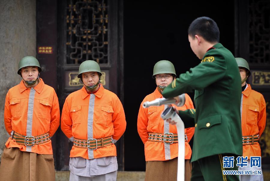 志愿消防队的僧人们穿上消防服参加演练(组图