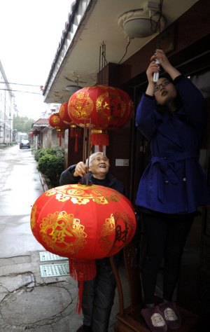 农历龙年临近,东城居民们贴春联,贴门神,挂灯笼,家家户户洋溢着新春的