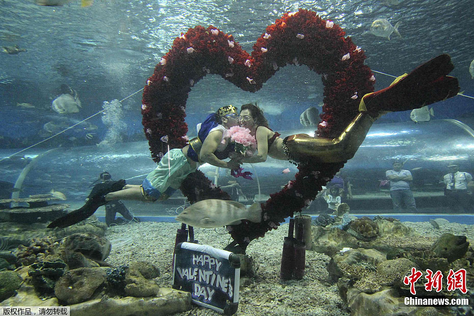 员扮演的海神和美人鱼在水下的心形装饰物