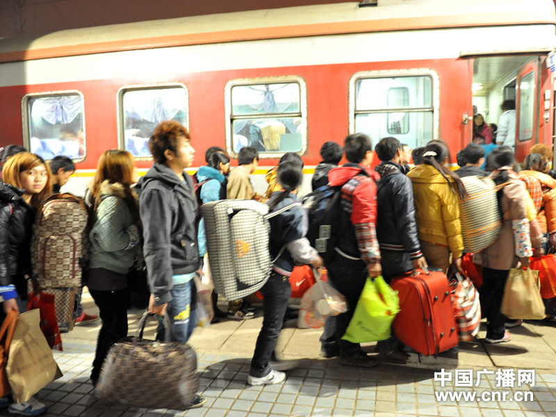列车工作人员同旅客一起把行李堆放在行李架上 图片来自中国广播网