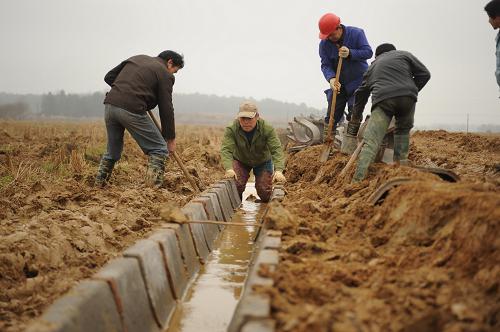 2月15日,施工人员在江西进贤县衙前乡抢修农田机耕道和灌溉沟渠.