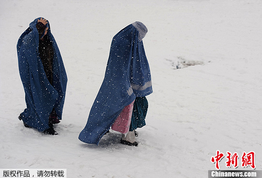 两名孩子在他们的住处旁玩耍,其中一名女孩穿着单薄,赤脚走在雪地上