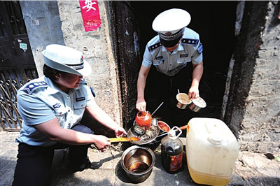 2011年5月，北京城管队员在一家违规制作盒饭的黑窝点查抄“地沟油”。（资料图片）本报记者潘之望摄