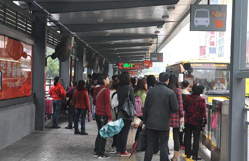 2月25日,乘客在广州一公交车站等车.新华社发记者 卢汉欣 摄