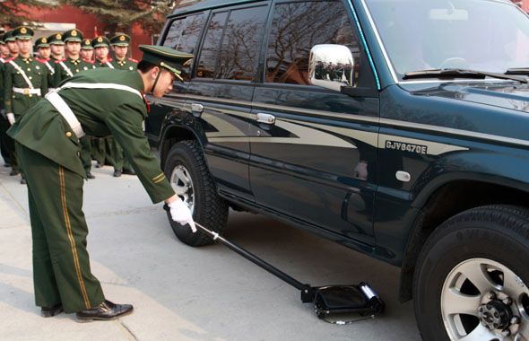 利用车底检查镜对车辆进行安检. 图片来源:人民武警报