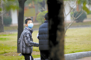 上周五,三水中学初中部一名戴口罩的学生准备去上课.