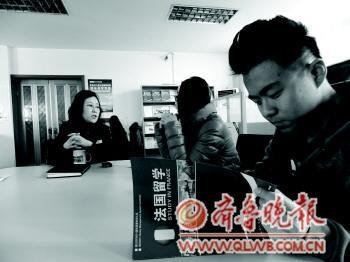 一家留学机构的咨询处,一名19岁的高中毕业生正在翻阅资料。