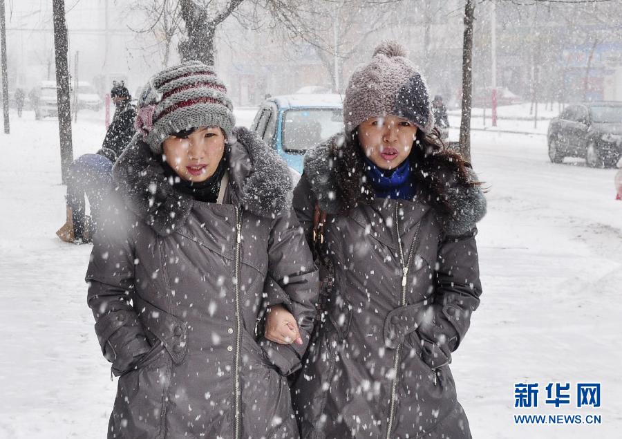 3月5日晚,雪花飘落辽宁大连,市民在雪中行走.