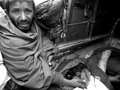 3月11日，一位阿富汗男子眼含热泪，旁边是被美军士兵射杀的平民尸体。