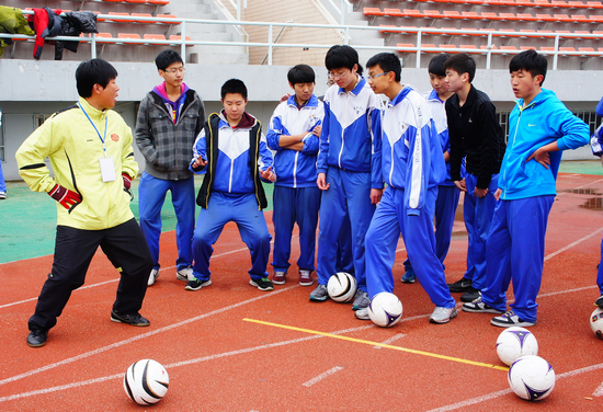 专业足球教练正在给学生们示范运球技巧