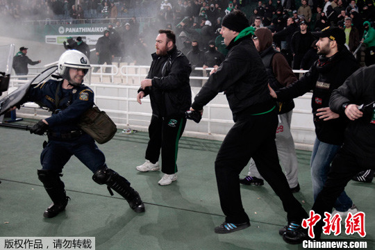 3月18日，希腊雅典奥林匹克体育场，希腊足球超级联赛发生球迷骚乱。图为帕纳辛纳克斯队球迷向警方扔掷燃烧弹。