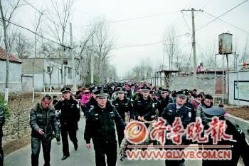 民警抬着被击毙的咬人狼走在村路上,引来大批村民围观。