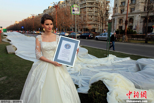 罗马尼亚一名模特20日身披一款裙摆长1.85英里(约2970米)的婚纱亮相，创造新的吉尼斯世界纪录。
