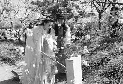 演员扮演的林黛玉和贾宝玉在北京大观园内"花冢"前表演"黛玉葬花"片段
