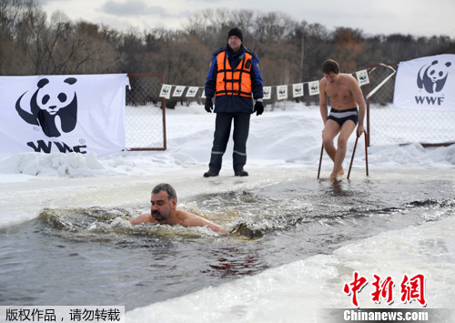 当地时间2012年3月28日，俄罗斯莫斯科，俄罗斯自然资源与生态部官员Anton Chernov在公园的冰湖中游行，呼吁公众关注北极水污染。