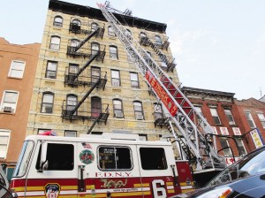 市场街一幢楼宇失火，消防车驾起云梯救人。美国《侨报》